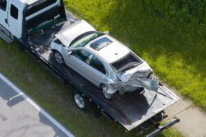 A car smashed, the driver wonders what to do after a truck accident.